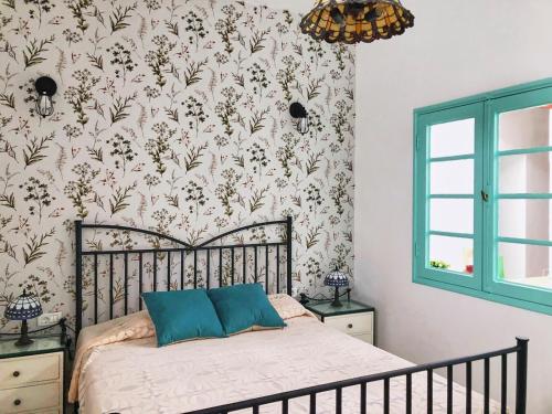 um quarto com uma cama com papel de parede floral em Casa Las Enanitas I - Casa Leo em Fuencaliente de la Palma