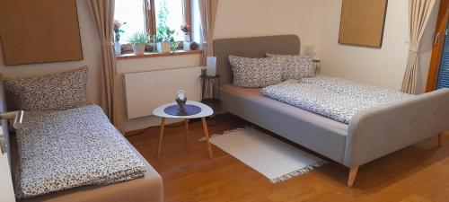 Apartment Zettler في Buxheim: غرفة نوم صغيرة بسريرين وطاولة
