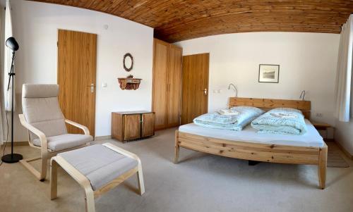 um quarto com uma cama e uma cadeira em Ferienwohnung Gästehaus Am Buchenbichl em Schönau am Königssee