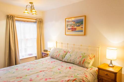a bedroom with a bed and two lamps and a window at Shoemakers Cottage - Norfolk Holiday Properties in Cromer