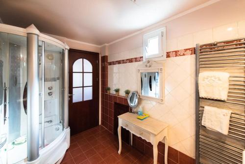 a bathroom with a shower and a table and a sink at Ολοκληρη Βιλα in Edessa