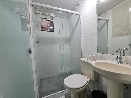 uma casa de banho com um chuveiro, um WC e um lavatório. em Hotel Supreme - Pistão Sul - Próximo ao Taguatinga Shopping em Taguatinga