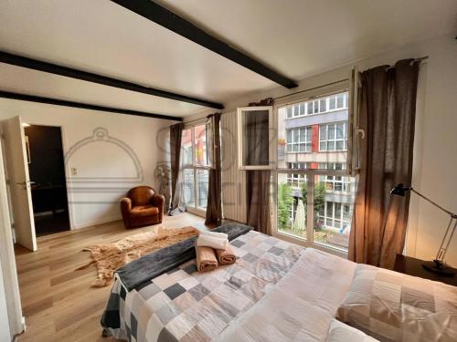 a bedroom with a bed and a large window at Le Loft - La Défense 4ch SOZEN C in Courbevoie