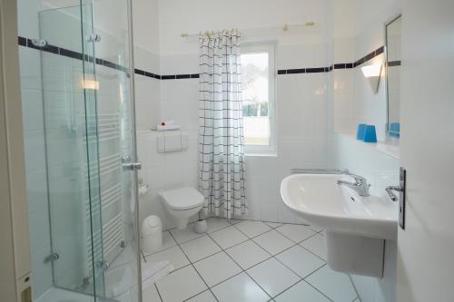 La salle de bains est pourvue d'un lavabo, de toilettes et d'une douche. dans l'établissement Villa Cremona Ferienwohnung 1, à Bansin