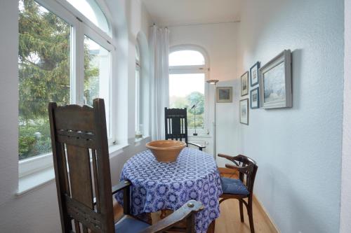 d'une salle à manger avec une table, des chaises et une fenêtre. dans l'établissement Villa Cremona Ferienwohnung 1, à Bansin