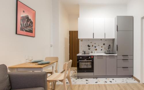 a kitchen and dining room with a table and a refrigerator at Golden Apartments/SobF in Katowice