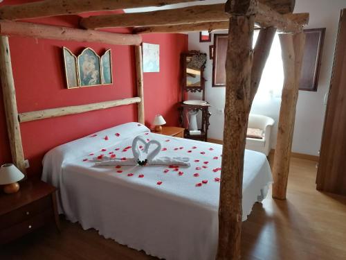 um quarto com uma cama branca e paredes vermelhas em La Hacienda Del Campo em Potes