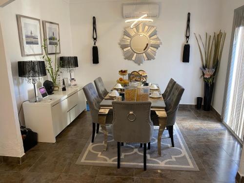 een eetkamer met een tafel, stoelen en een klok bij Casa Dolly Boutique B&B in Cantoria