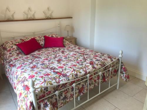 a bed with red pillows on it in a bedroom at The Studio in Wisborough Green