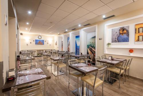 a restaurant with tables and chairs and a clock on the wall at Best Quality Hotel Gran Mogol in Turin