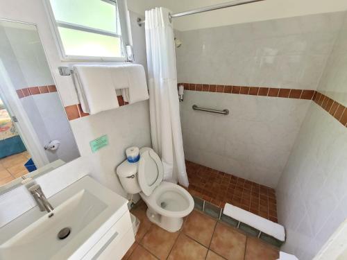 a bathroom with a toilet and a sink at Parador Maunacaribe - Maunabo in Maunabo