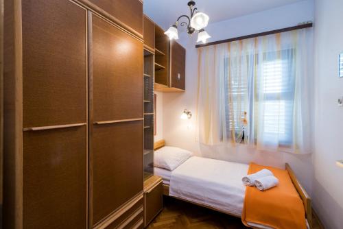 a small bedroom with a bed and a window at Apartman Ana in Krk