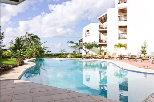 a swimming pool in front of a building at Sunset Condo @ Villas Mayaluum in Cozumel