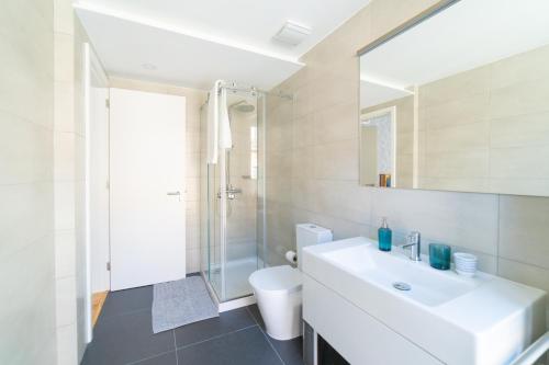 uma casa de banho com um lavatório, um chuveiro e um WC. em Blue by the River 1 - elegant two-bedroom in Santos em Lisboa