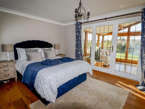 a bedroom with a bed and a large window at Manor Wood in Coddington
