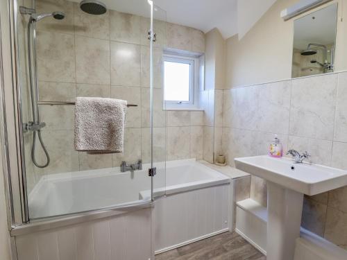 a bathroom with a shower tub and a sink at Manor Wood in Coddington