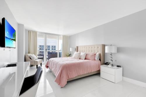 - une chambre blanche avec un lit et une télévision dans l'établissement Bayview Bliss Biscayne, à Miami