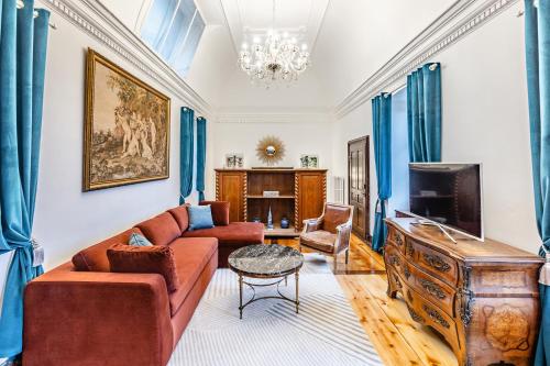 ein Wohnzimmer mit einem Sofa und einem TV in der Unterkunft Château du Châtelard in Montreux