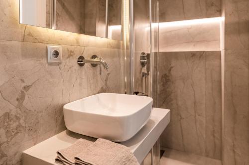een badkamer met een witte wastafel en een douche bij A bright Nest in the heart of Plaka in Athene