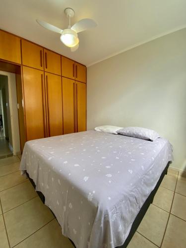 Schlafzimmer mit einem weißen Bett und einer Decke in der Unterkunft Apartamento em Olimpia in Olímpia