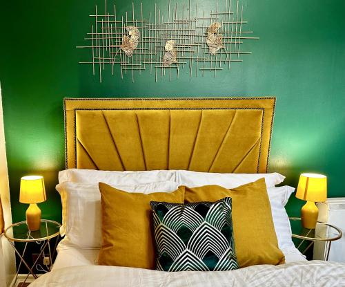 um quarto com uma parede verde e uma cama com 2 candeeiros em Spacious 1 bedroom apartment in the best location in Manchester City Centre em Manchester