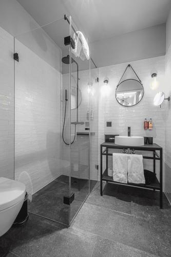 a bathroom with a shower and a toilet and a sink at ALPINE INN Davos in Davos