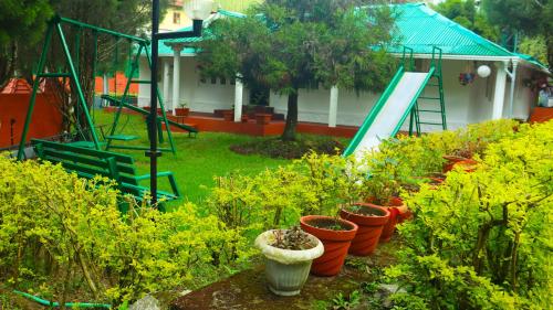 a row of plants in a garden with a playground at GOLDEN GREEN in Munnar