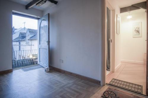 an empty hallway with a door leading to a balcony at The Penthouse At The Mews - 2 Bedroom Apartment - Tenby in Tenby