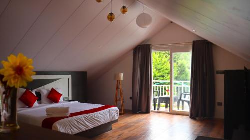 a bedroom with a bed in a attic with a window at GOLDEN GREEN in Munnar