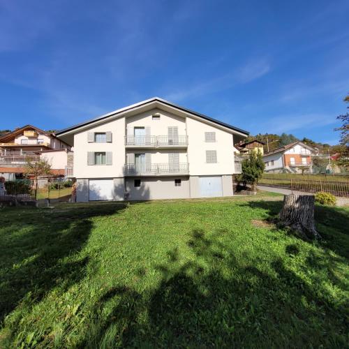 a large white house with a yard at Attic House Mountain Lake Iseo Hospitality in Bossico