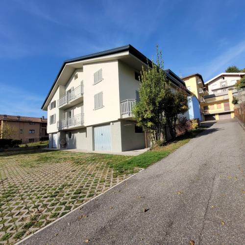 a white apartment building on a cobblestone street at Attic House Mountain Lake Iseo Hospitality in Bossico