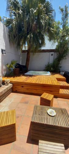 a patio with wooden benches and palm trees at Mucho Bonito Hostel in Santa Fe