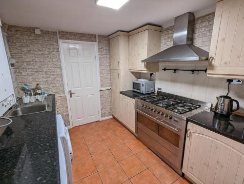 a kitchen with a stove and a sink in it at Penarth Town Terrace, close to cafes, beaches, Cardiff in Cardiff
