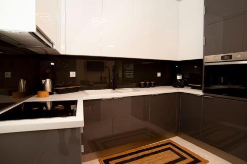 a kitchen with black and white cabinets and a stove at Oniro Home in Ierápetra