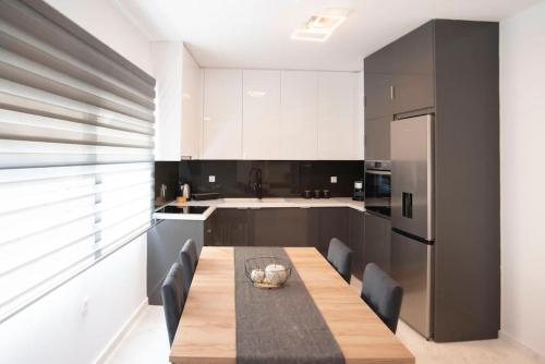 a kitchen with a dining table and a refrigerator at Oniro Home in Ierápetra