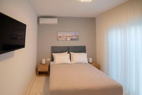 a bedroom with a bed and a flat screen tv at Oniro Home in Ierápetra