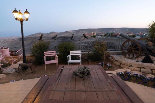 a wooden deck with two chairs and birds on a hill at House of Art in Arad