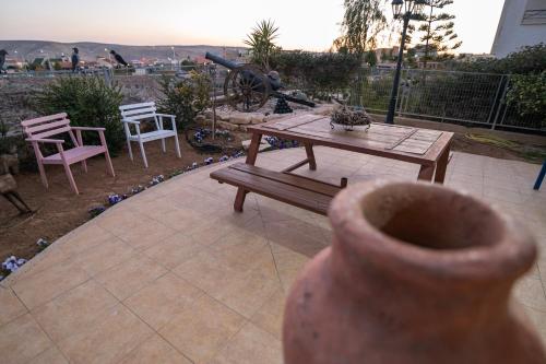 a vase sitting on a patio with a table and chairs at House of Art in Arad