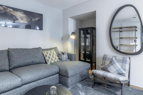 a living room with a couch and a chair and a mirror at ALPINE INN Davos in Davos