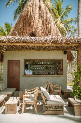 a resort with two chairs and a thatch roof at Zai Patacho in Pôrto de Pedras