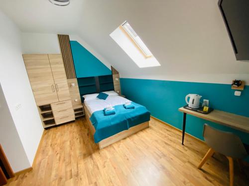 a bedroom with a bed and a blue wall at Stary Piernik in Grzybowo