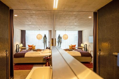 a bathroom with two beds and a mirror at Nomad Design & Lifestyle Hotel in Basel