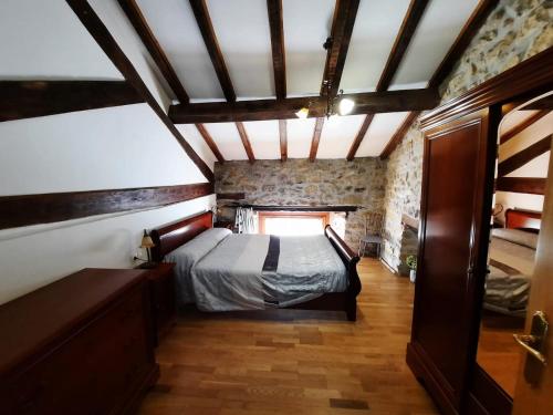 a bedroom with a bed in a room with a brick wall at Errotazar apartamento E in Alsasua