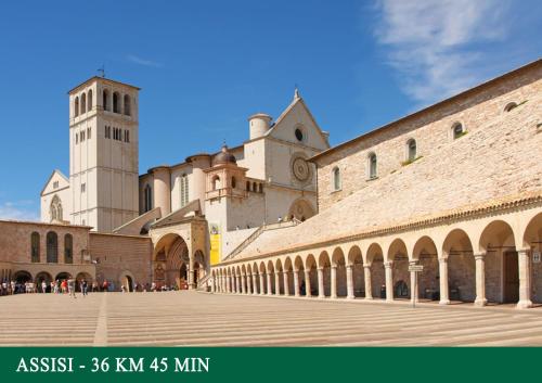 a large building with a clock tower in the background at Agriturismo Sant'Angelo holiday farm in Gualdo Cattaneo
