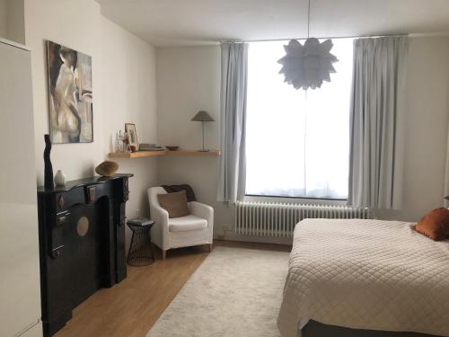 - une chambre avec un lit, une chaise et une fenêtre dans l'établissement B&B Alexander, à Maastricht
