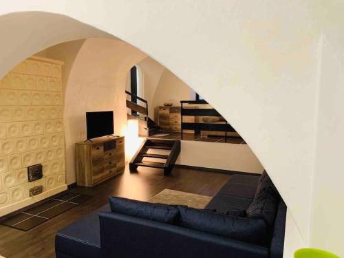 a living room with a couch and a room with a staircase at Nuovo Casa in Sopron