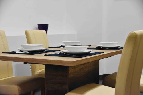 a wooden table with bowls and plates on it at Nuovo Casa in Sopron
