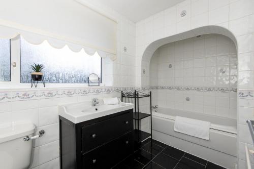 欣克利佛的住宿－Mitford Close，白色的浴室设有水槽和浴缸。