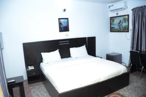 um quarto com uma cama grande e uma cabeceira preta em House 5 Ibara Housing, Abeokuta em Abeokuta