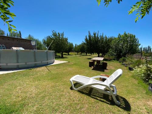 ein weißer Stuhl auf dem Rasen im Hof in der Unterkunft El Nono in General Alvear